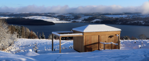 Snow-covered roll-off roof observatory overlooking Loch Ness